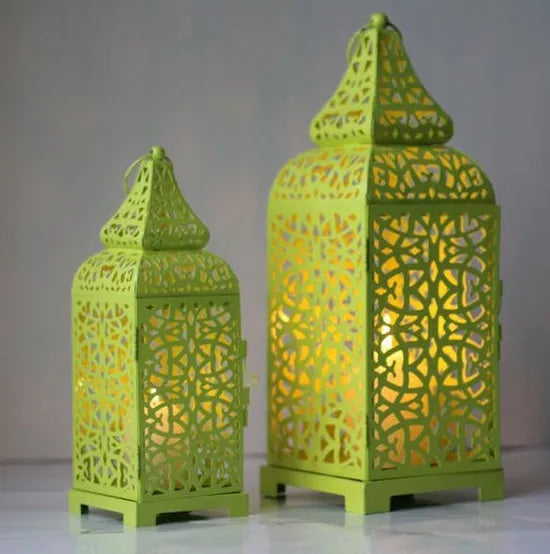 Blue geometric iron Moroccan tea light lantern candelabra with hanging ornaments on a table.