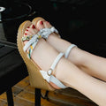 Women's pink wedge sandals with a thick platform heel and buckle strap.