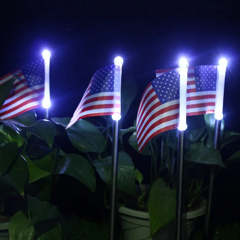 Solar garden flag light with stainless steel pole showing American flag design illuminated at night