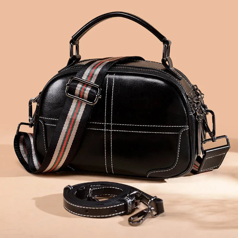 Round leather handbag with zip closure and soft double handles in wine red colour