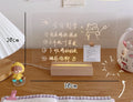 LED bedside lamp with optional message board design on a nightstand.