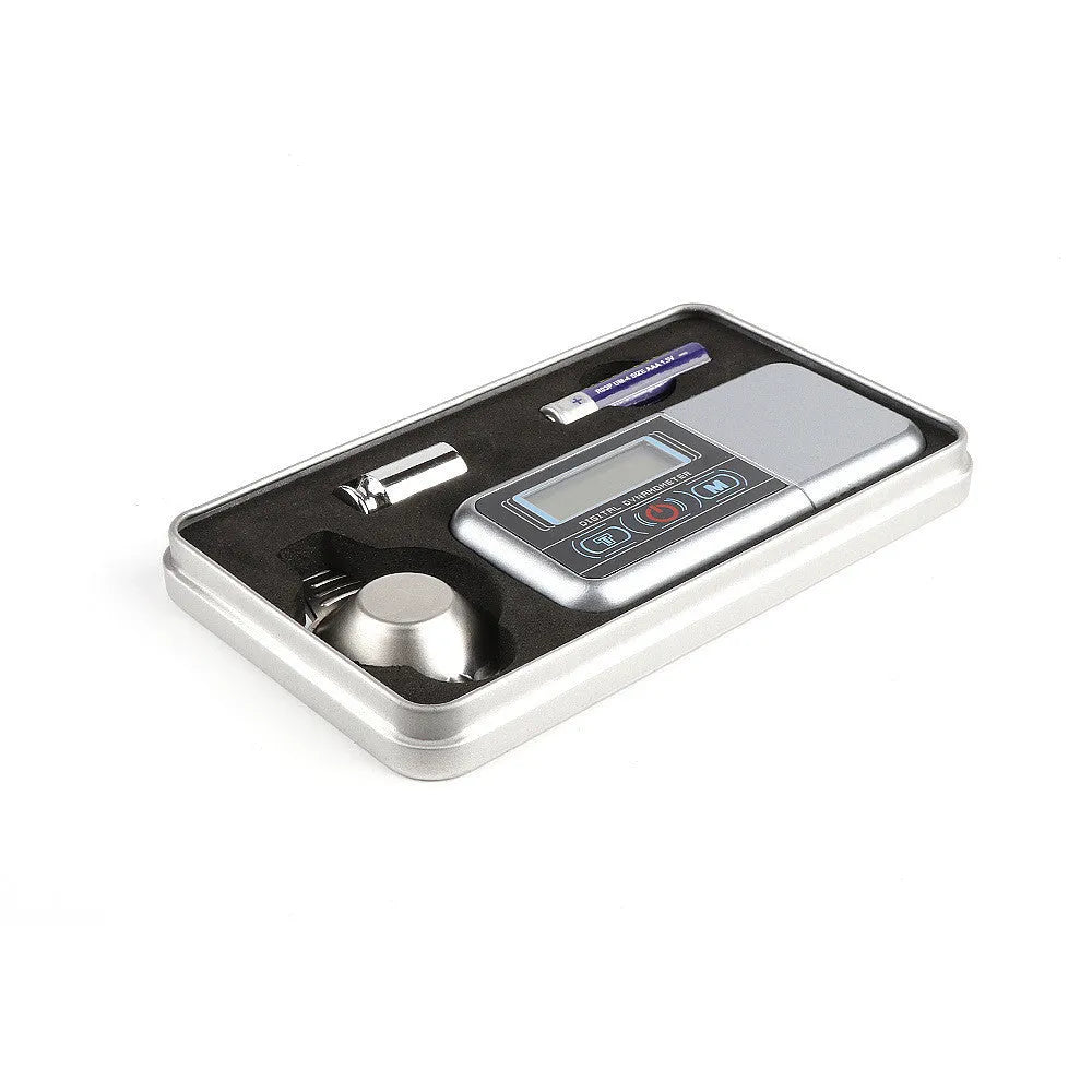 Compact black digital pocket scale on a table showing 0.00g on its LCD display.