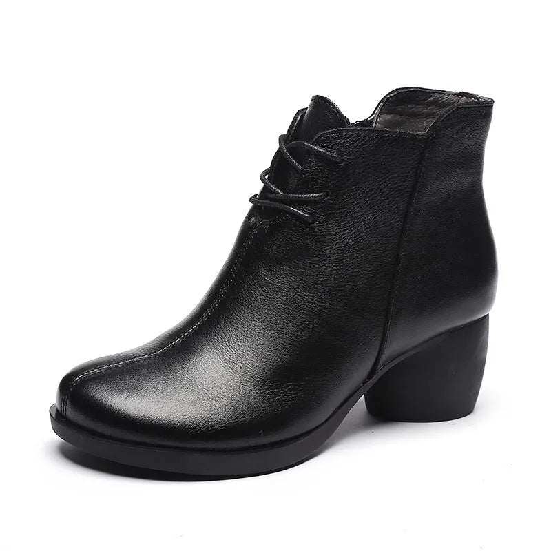 Women's brown leather Martin boots with a thick block heel and round toe on a wooden floor.