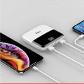 White portable power bank with digital display showing battery percentage and two USB ports.