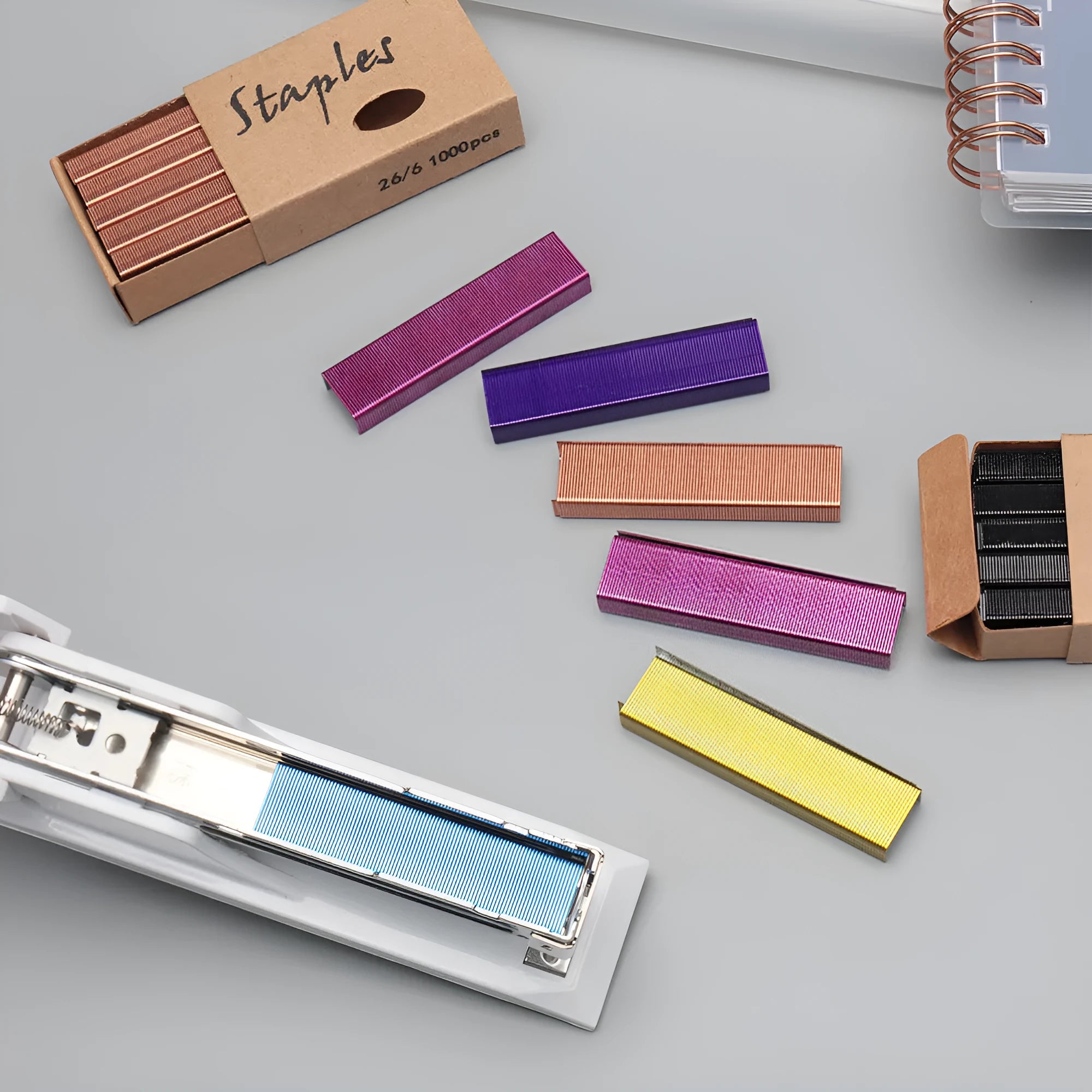 Box of 1000 metal stitching needle staples in black, purple, rose gold, and rose red colours.