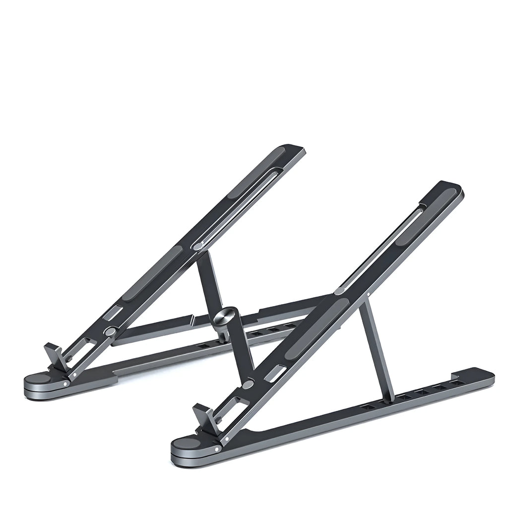 A folded aluminium laptop stand in silver next to an open laptop, demonstrating its compact size.