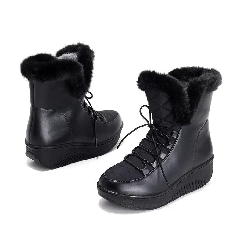 Women's black lace-up winter boots with a platform sole and plush lining on a wooden floor.