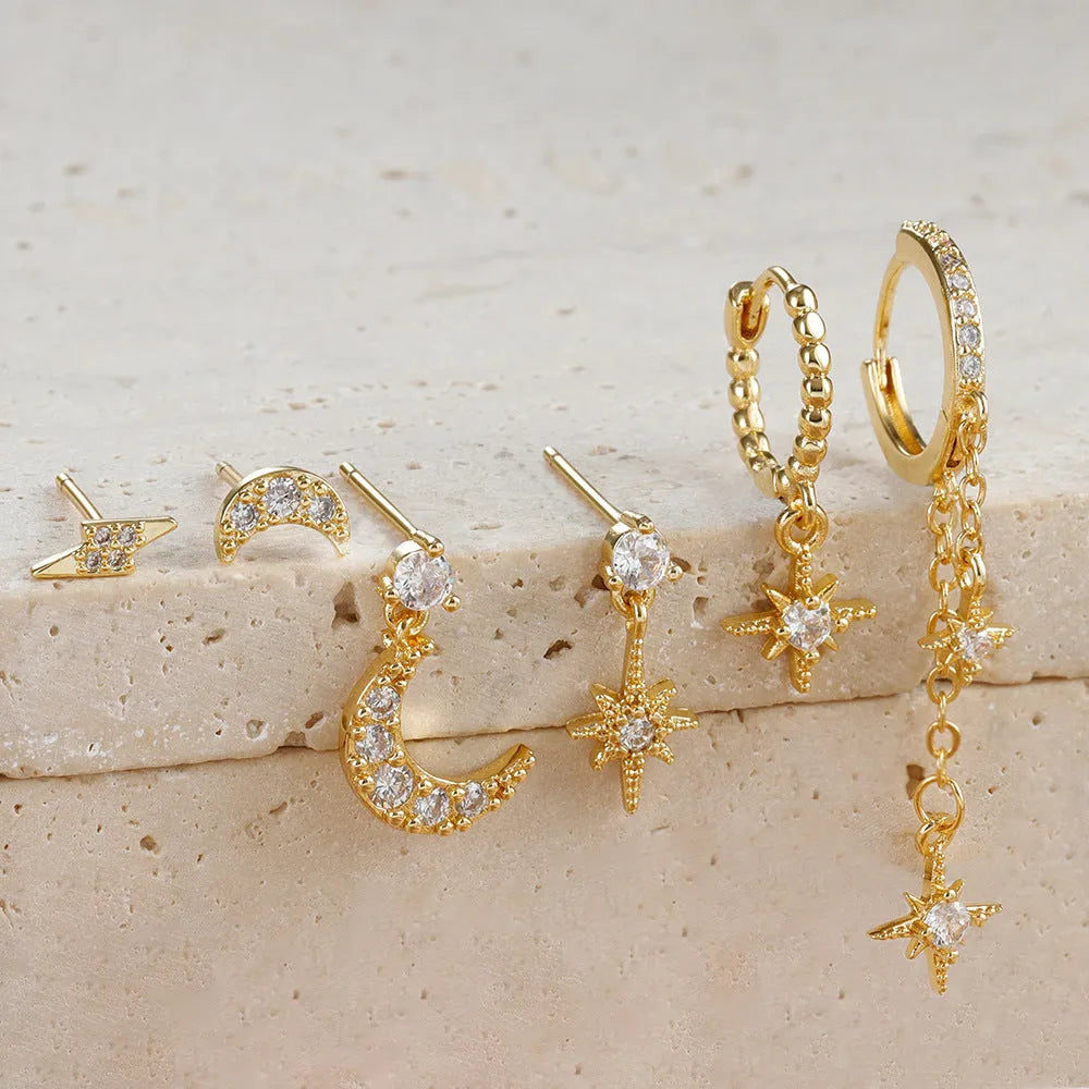 Six pairs of gold chain tassel earrings with zircon studs displayed together