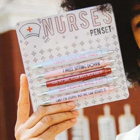 Five nurse-themed retractable ballpoint pens laid out, showing humorous medical designs.