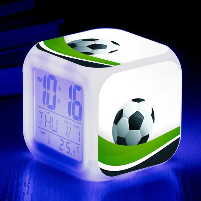Square plastic alarm clock with football pattern design showing four alarm settings and USB charging port