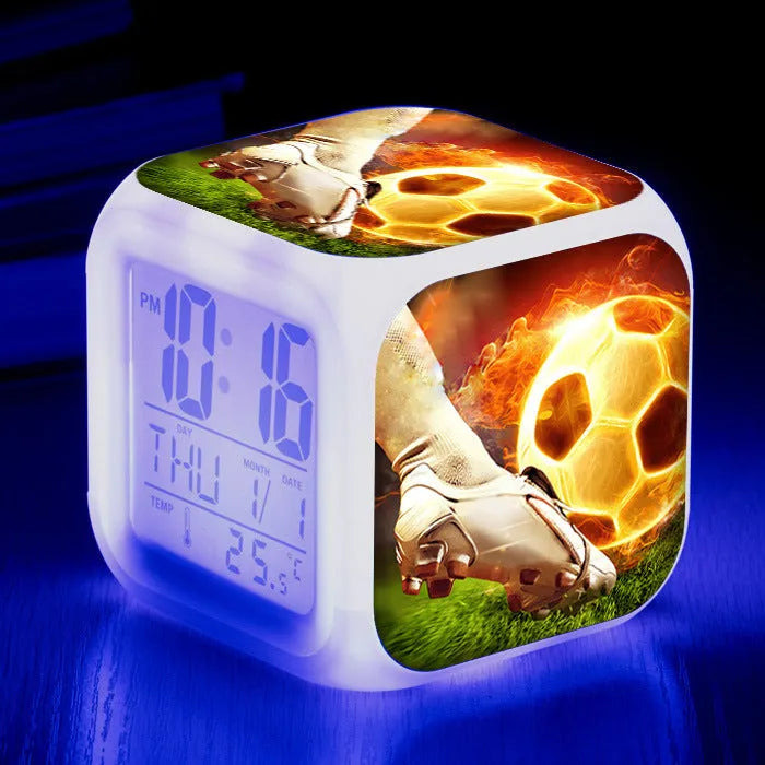 Square plastic alarm clock with football pattern design showing four alarm settings and USB charging port