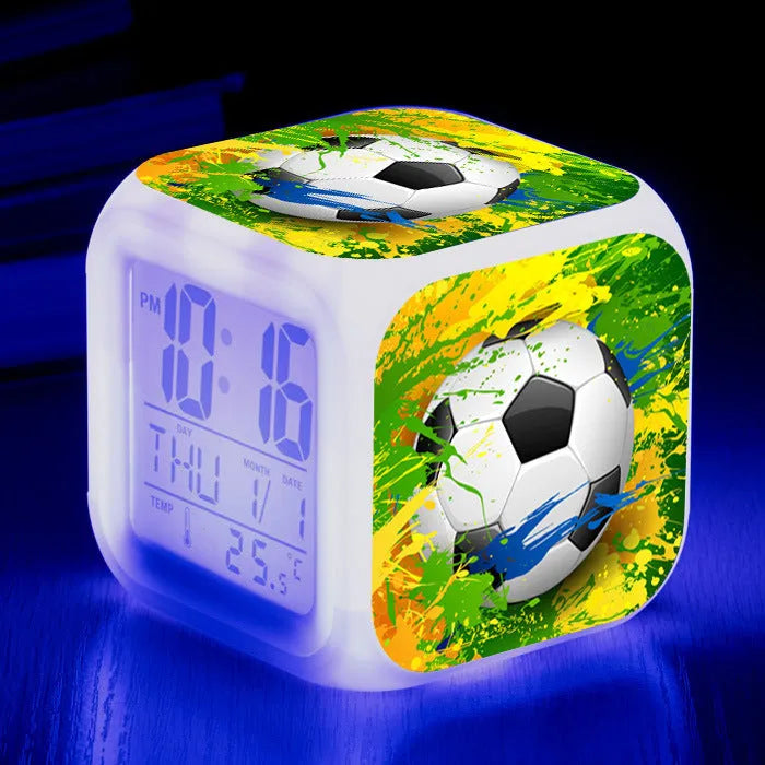 Square plastic alarm clock with football pattern design showing four alarm settings and USB charging port