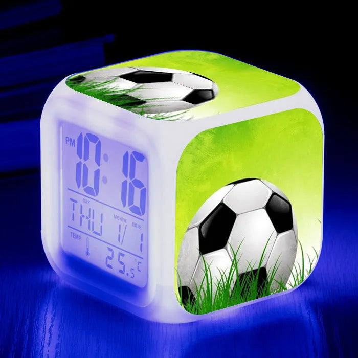 Square plastic alarm clock with football pattern design showing four alarm settings and USB charging port