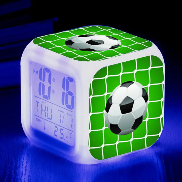 Square plastic alarm clock with football pattern design showing four alarm settings and USB charging port