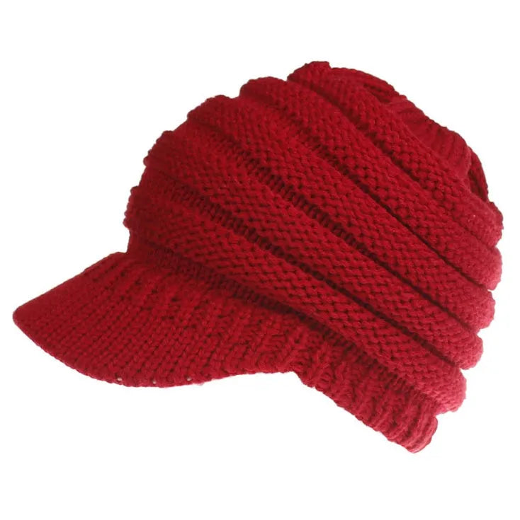 Woman wearing a soft knitted beanie with a ponytail pulled through the hole at the back.