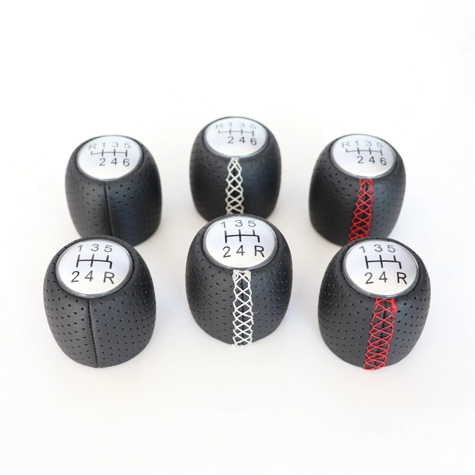 Sewn wrapped black perforated leather gear shift handball for Alpha vehicles on a silver cover.