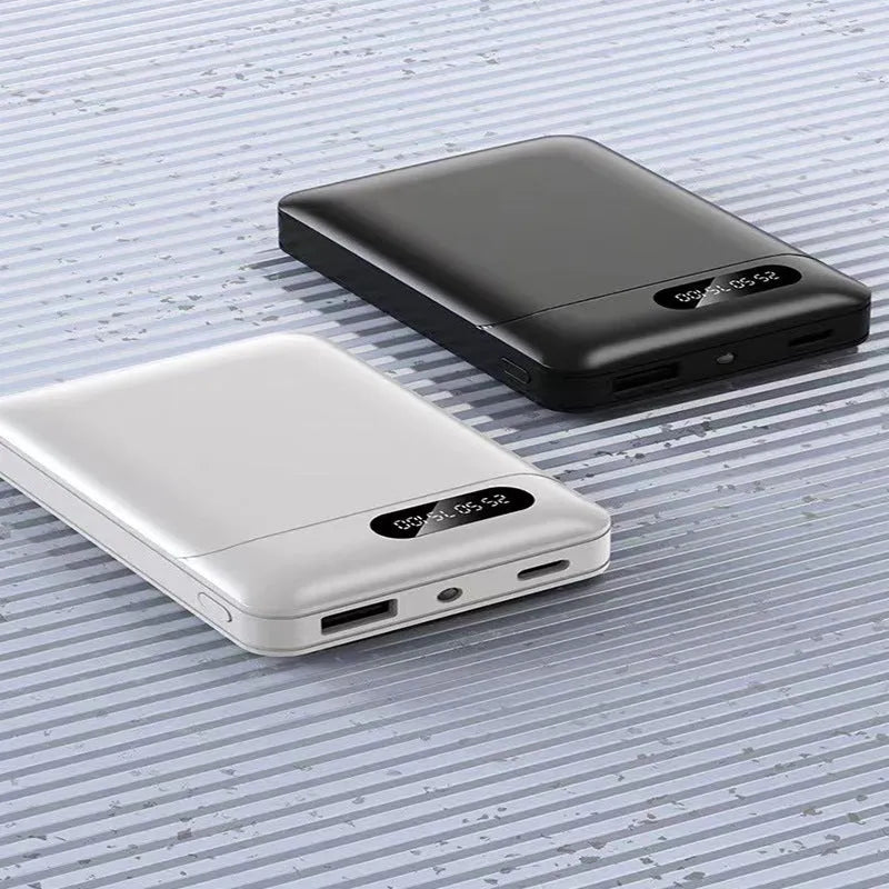 White or black large capacity portable power bank with multiple USB ports, shown next to a smartphone.