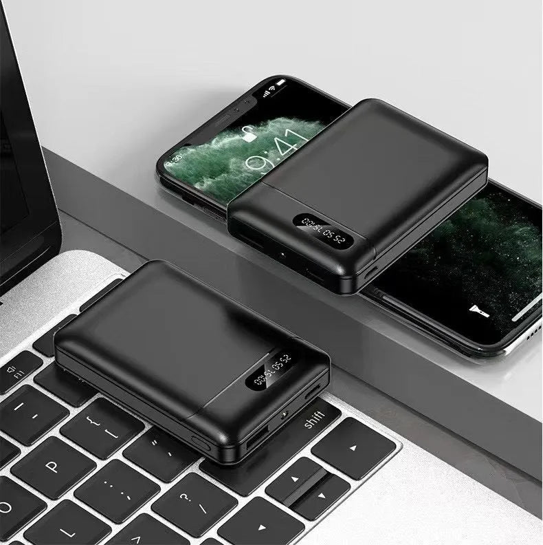 White or black large capacity portable power bank with multiple USB ports, shown next to a smartphone.