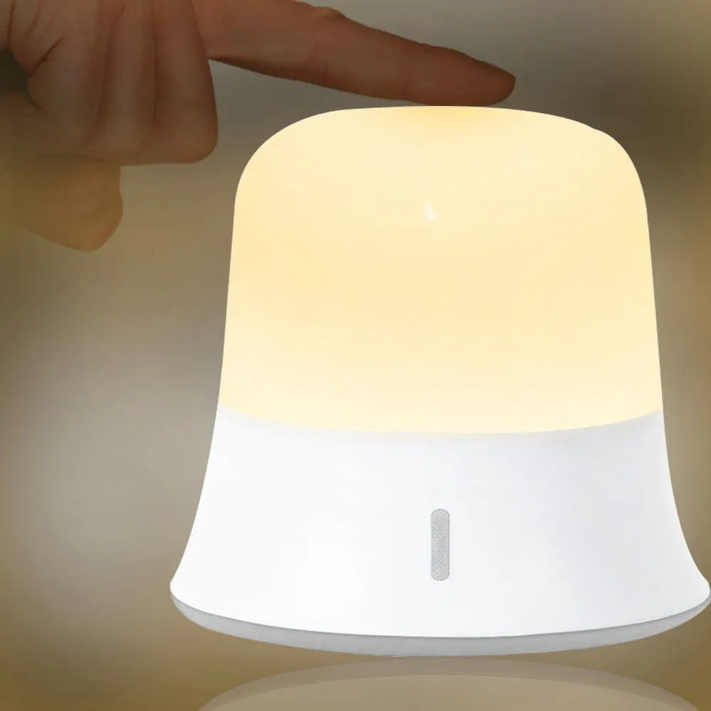 White rechargeable touch control night light with dimmer and motion sensor on a bedside table.