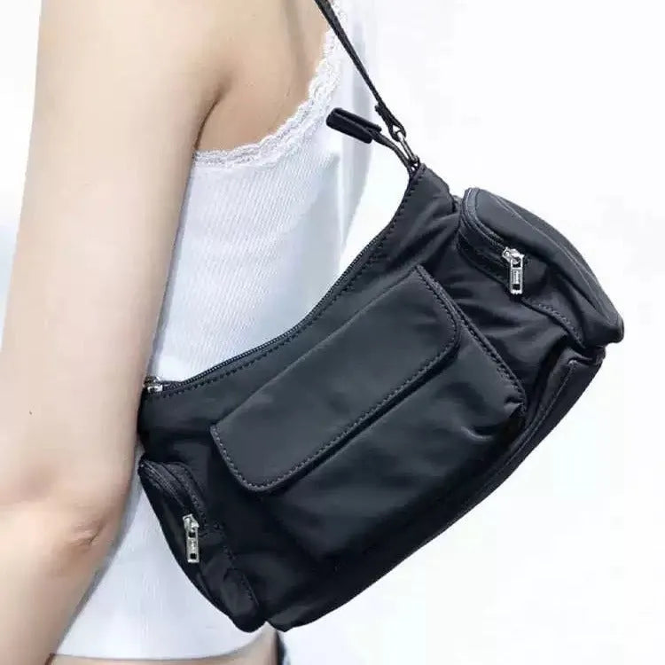 Black women's shoulder bag with two front pockets showing side line stitching detail