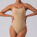 Sleeveless slim grey yoga jumpsuit for women on a model, showing tight fit and moisture-wicking fabric.
