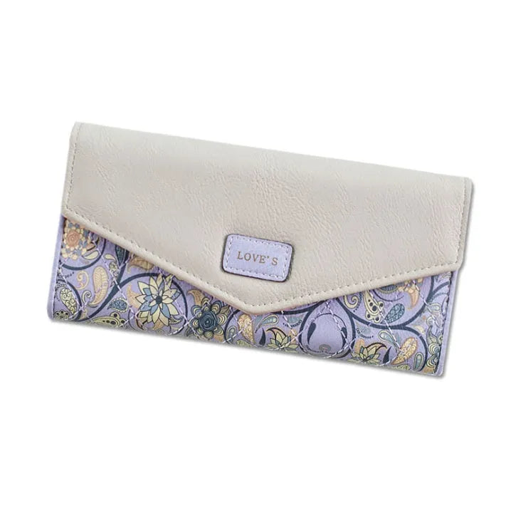 Women's black trifold leather wallet with buckle clip closure showing card slots and coin compartment