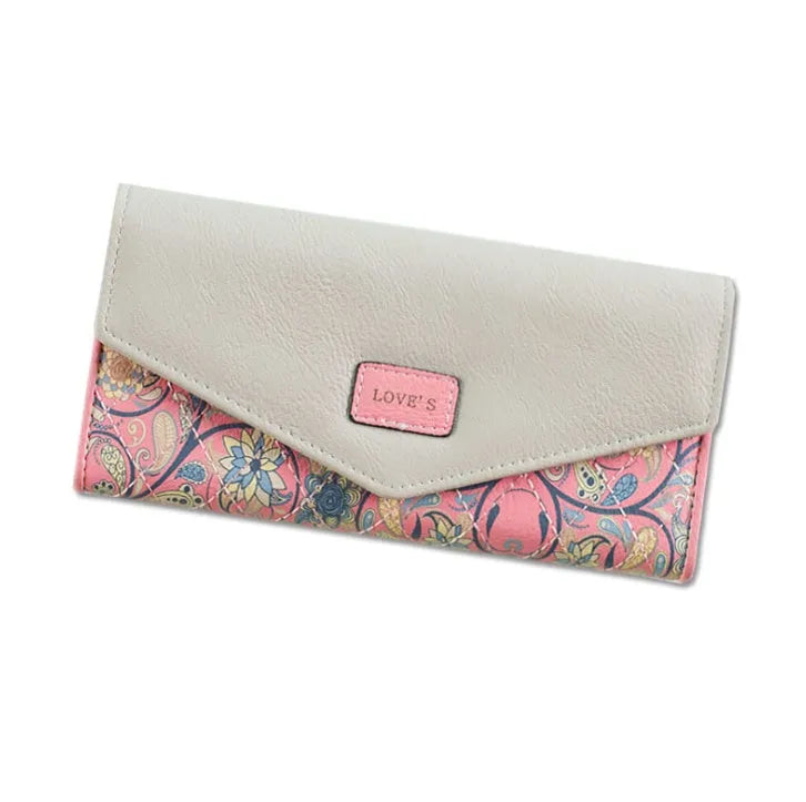 Women's black trifold leather wallet with buckle clip closure showing card slots and coin compartment