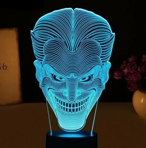 3D LED table lamp showing seven colour options with remote control and USB cable on wooden surface