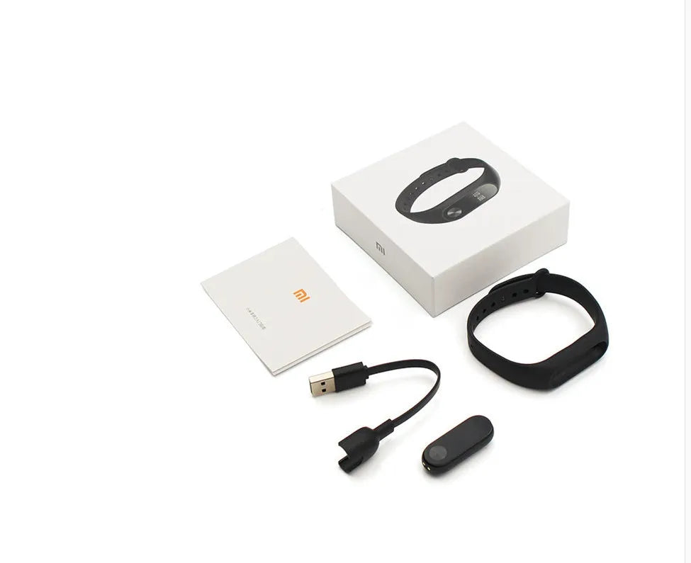 Xiaomi Mi Band 2 black smartband on wrist showing OLED display with heart rate and step count.