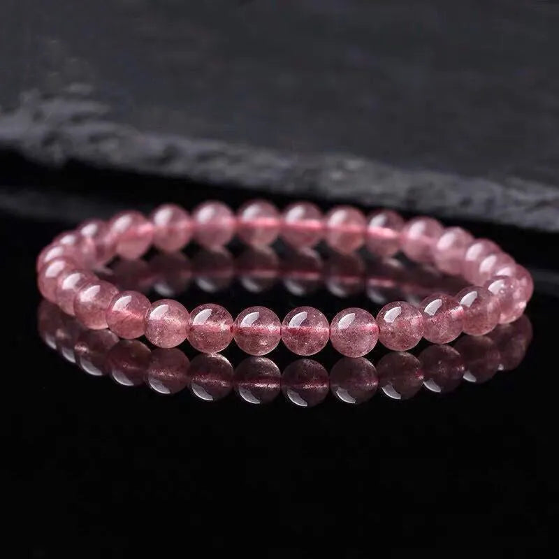 Women's strawberry quartz crystal bracelet with polished beads on an elasticated string.