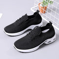 Women's black mesh casual sneakers with round toe and white lace-up front on a grey PVC sole.