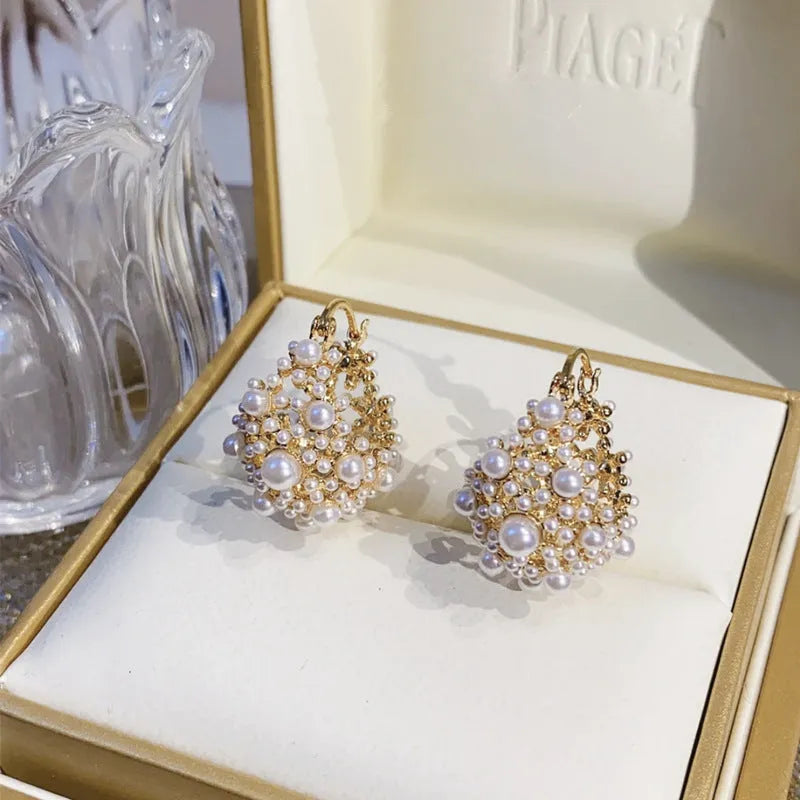 Gold-coloured copper flower basket earrings with rice-shaped bead decoration and pearl inlay detailing
