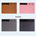 Pink PU leather wireless charging mouse pad with integrated phone holder on a desk.
