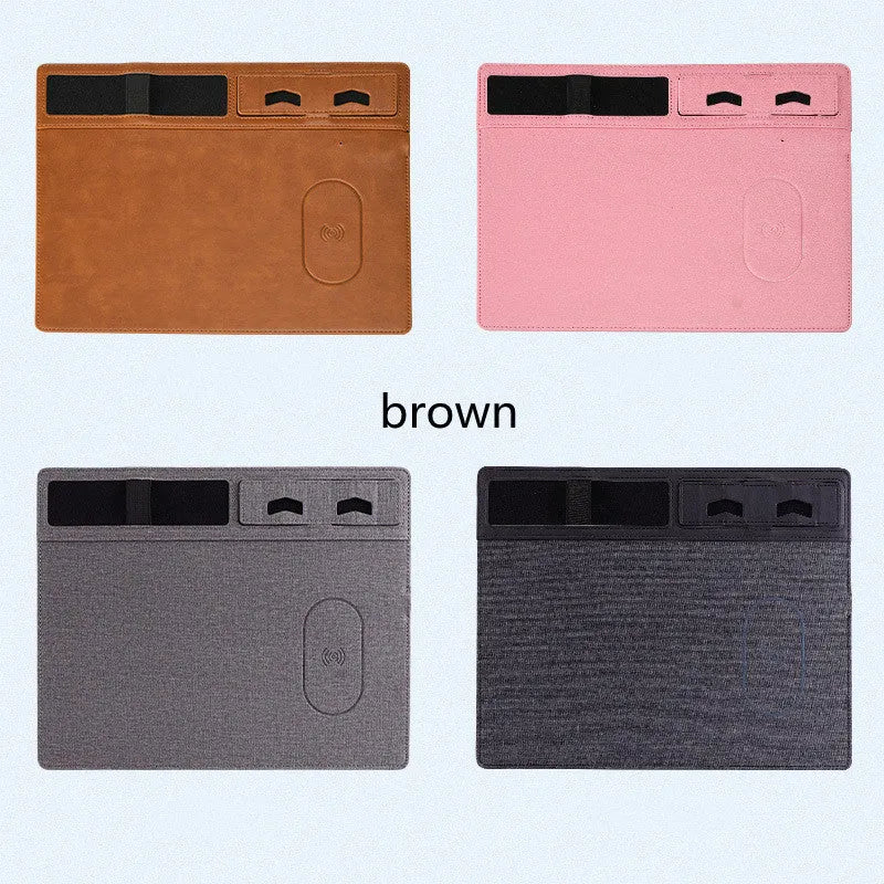 Pink PU leather wireless charging mouse pad with integrated phone holder on a desk.