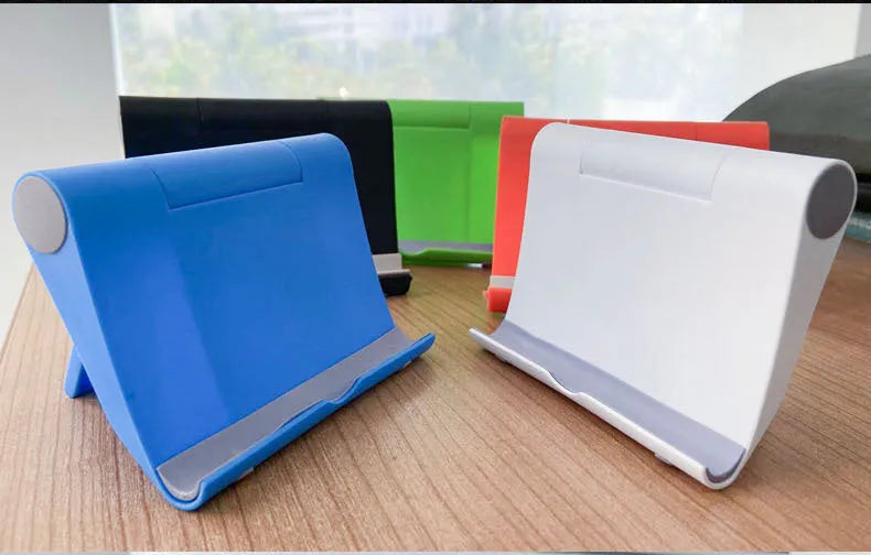 Black PE folding tablet stand holding a mobile phone at an angle on a wooden desk.