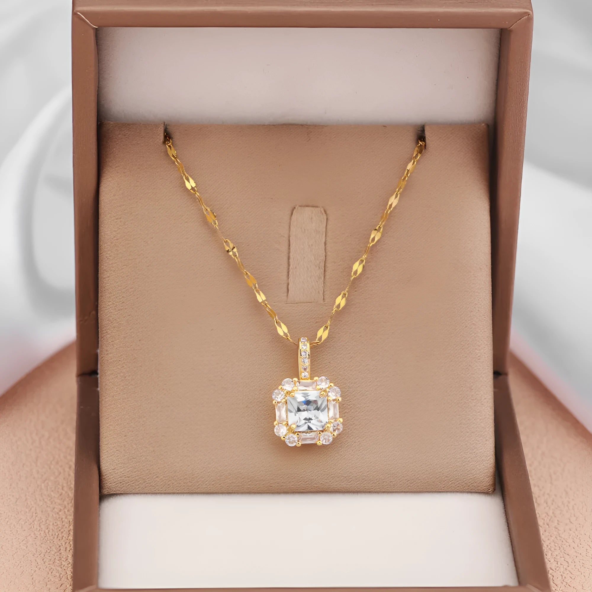 Gold tone geometric quadrilateral pendant necklace with inlaid zircon stones on a water wave chain.