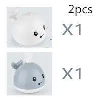 Whale-shaped electric bath toy spraying water with flashing lights, on a blue base.