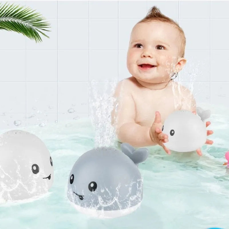 Whale-shaped electric bath toy spraying water with flashing lights, on a blue base.