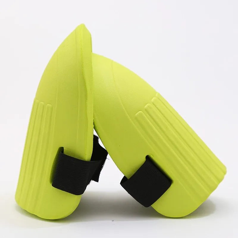 A pair of thick EVA foam kneepads in army green colour on a garden soil background.