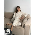 White women's floral print bell sleeve top and wide leg pants casual suit set laid flat