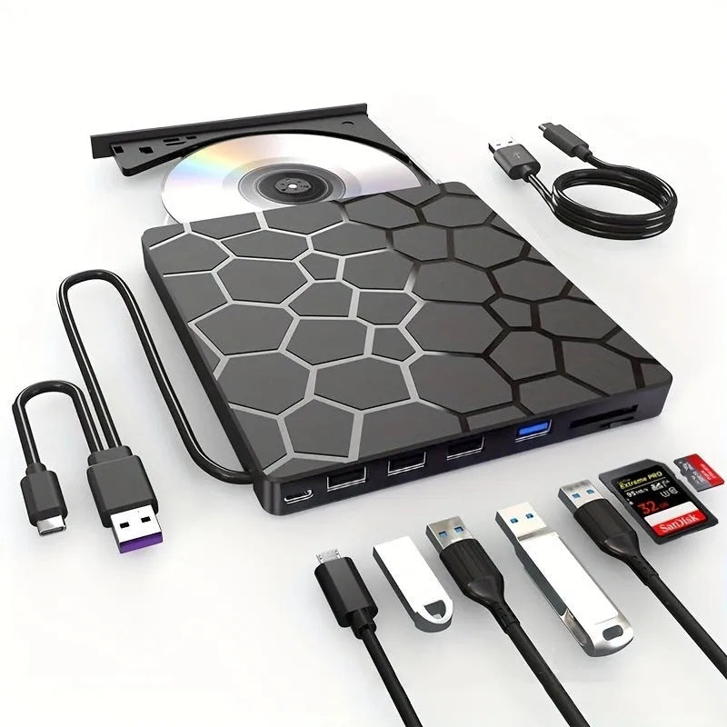 Black external USB CD/DVD writer and reader drive on a desk next to a laptop.
