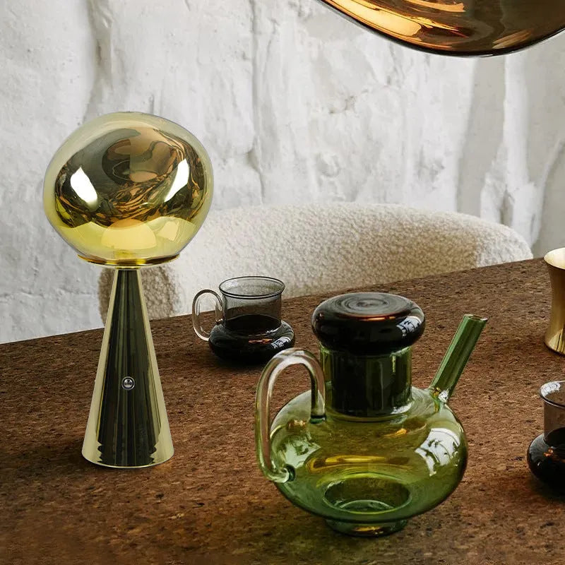 Volcanic lava mini table lamp with metal holder in gold finish, USB magnetic charging, on a bedside table