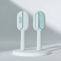 Blue pet grooming comb with water tank for dogs and cats on a white surface.