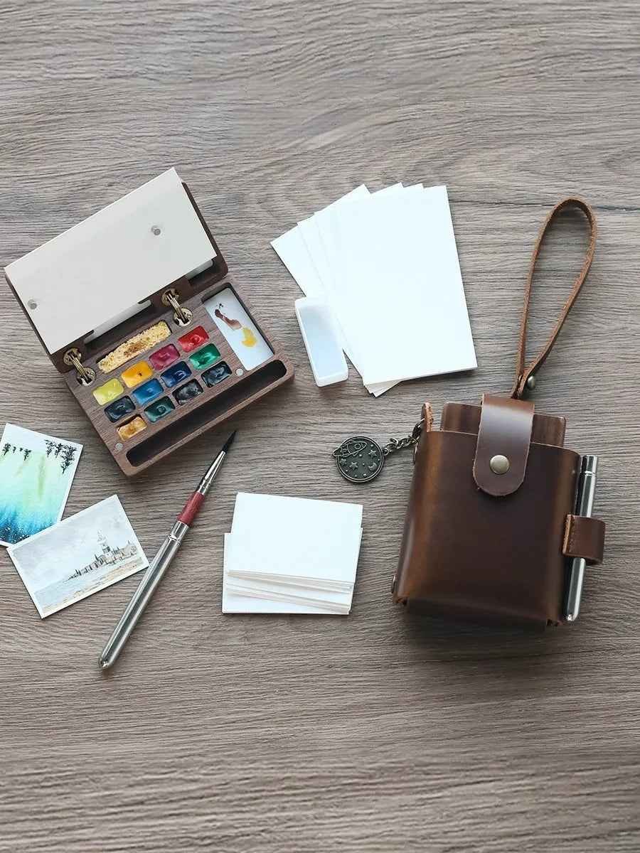Mini wooden watercolour paint box with pigment suit inside, closed lid showing walnut-colour finish