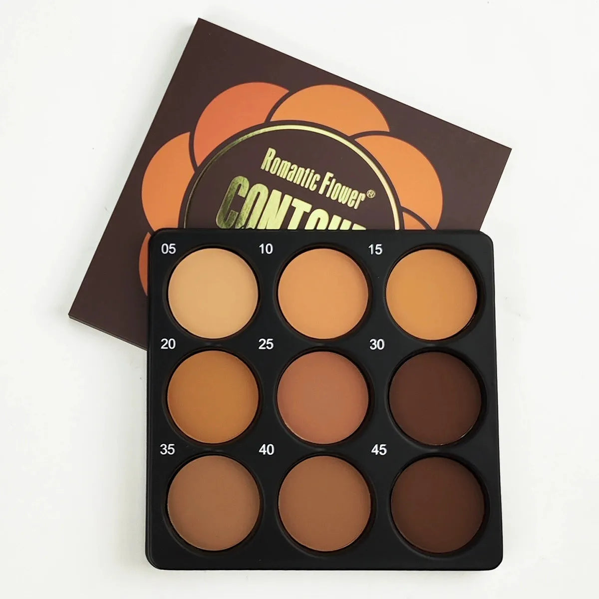 Open dark matte eyeshadow palette showing nine dark coloured pans with a repair disk.