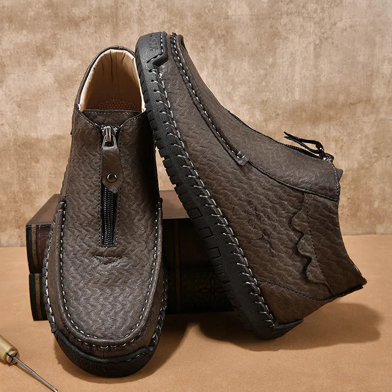 Men's black slip-on leather loafers with round toe and stitching detail on a solid colour background.