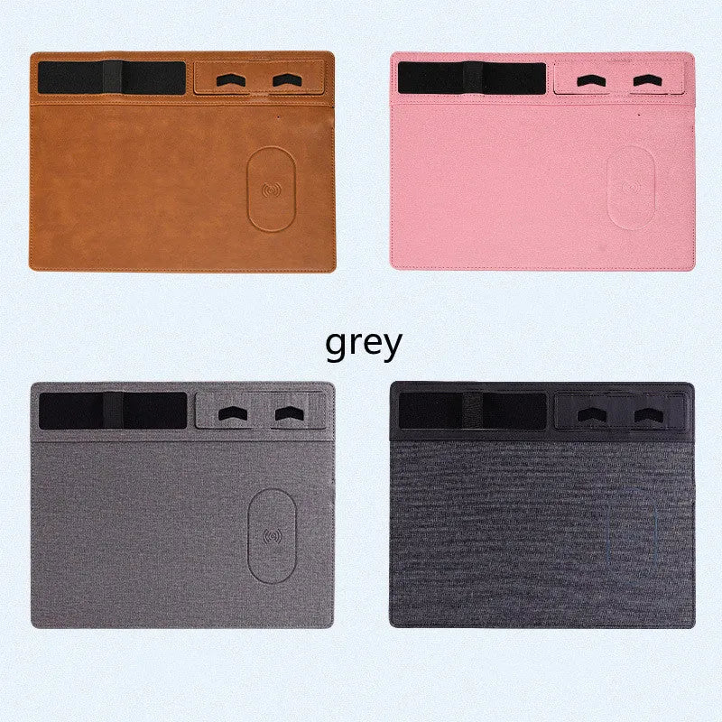 Pink PU leather wireless charging mouse pad with integrated phone holder on a desk.