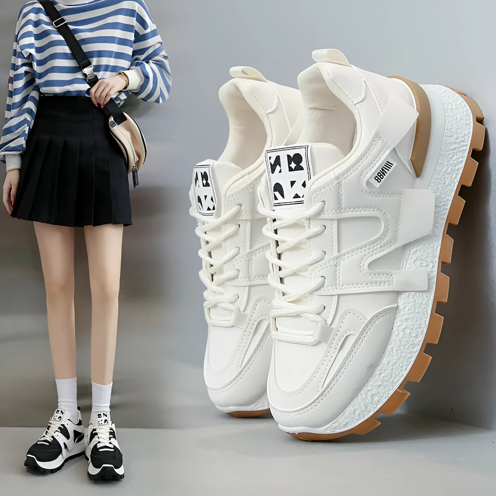 White and black unisex low-top sneakers with round toe and front lace-up on rubber sole