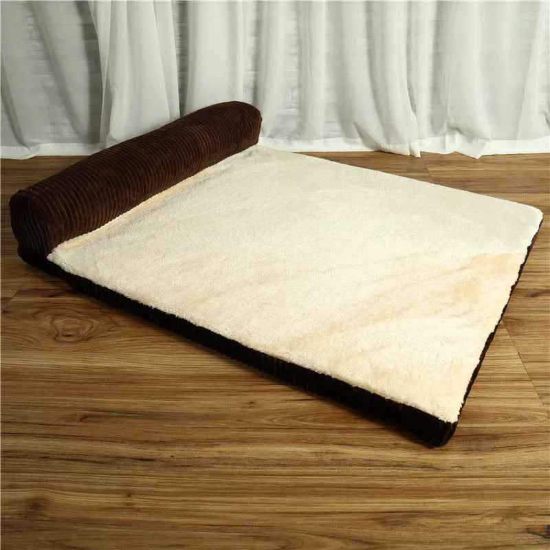 A corduroy pet sofa dog bed with a raised bolster, shown in a grey colour on a wooden floor.