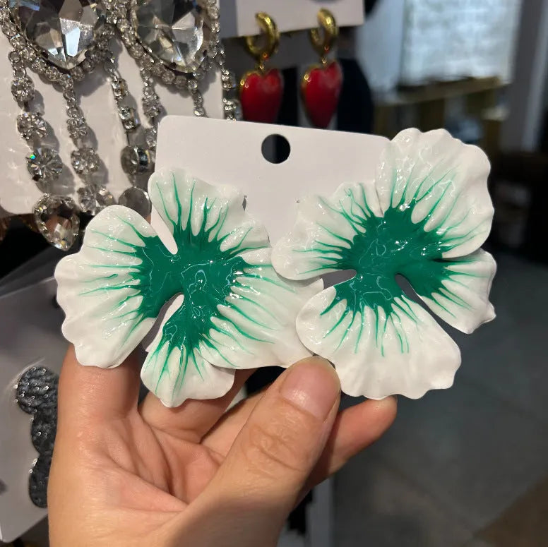 Close-up of alloy floral stud earrings with oil-spot glaze in blue, green, purple, and rose colour options.